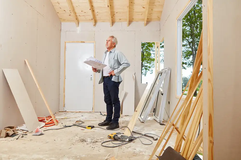 A senior man overseeing renovations on his home.