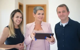 Three business people in an office hallways.